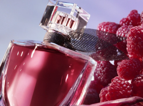 Parfümflakon von La Vie Est Belle L'Elixir umgeben von frischen Himbeeren