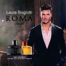 Werbeanzeige für das Parfum Laura Biagiotti Roma Uomo Nero Estremo. Ein eleganter Mann in einem dunklen Anzug mit offenem Hemd steht in einer stimmungsvoll beleuchteten Umgebung. Neben ihm sind zwei Parfumflakons zu sehen – ein schwarzer und ein bernsteinfarbener. Der Schriftzug 'Laura Biagiotti ROMA UOMO' ist prominent im Bild.